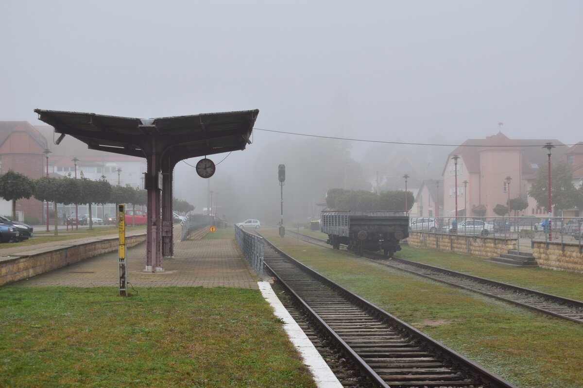 Blich auf den alten Bahnhof Überherrn am Morgen des 30.9.2023. Der Verkehr auf der Strecke Völklingen - Überherrn - Thionville wurde schrittweise ab 1972 eingestellt. 1972 erfolgte die Einstellung auf dem Abschnitt Überherrn – Grenze Hargarten. 1992 erfolgte die Einstellung des Personenverkehrs auf dem Abschnitt Überherrn - Völklingen. 1995 wurde die Oberleitung abgebaut. 2003 wurde der Verkehr entgültig eingestellt und die Strecke stillgelegt. 2003 pachtete Mosolf die Strecke für den Güterverkehr. 2016 wurde der Verkehr wegen Oberbaumängel eingestellt. Es gab bis jetzt immer wieder Vorschläge zur Reaktivierung welche bis heute nicht erfolgte. Da die Strecke nur stillgelegt und nicht entwidmet ist, ist hier eine Reaktivierung jedoch möglich. 

Überherrn 30.09.2023