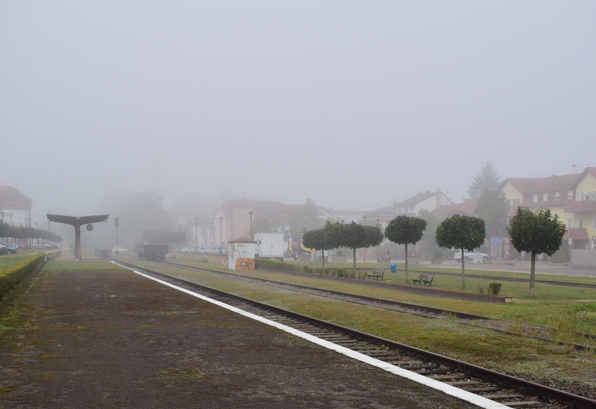 Blich auf den alten Bahnhof Überherrn am Abend des 30.9.2023. Der Verkehr auf der Strecke Völklingen - Überherrn - Thionville wurde schrittweise ab 1972 eingestellt. 1972 erfolgte die Einstellung auf dem Abschnitt Überherrn – Grenze Hargarten. 1992 erfolgte die Einstellung des Personenverkehrs auf dem Abschnitt Überherrn - Völklingen. 1995 wurde die Oberleitung abgebaut. 2003 wurde der Verkehr entgültig eingestellt und die Strecke stillgelegt. 2003 pachtete Mosolf die Strecke für den Güterverkehr. 2016 wurde der Verkehr wegen Oberbaumängel eingestellt. Es gab bis jetzt immer wieder Vorschläge zur Reaktivierung welche bis heute nicht erfolgte. Da die Strecke nur stillgelegt und nicht entwidmet ist, ist hier eine Reaktivierung jedoch möglich. 

Überherrn 30.09.2023