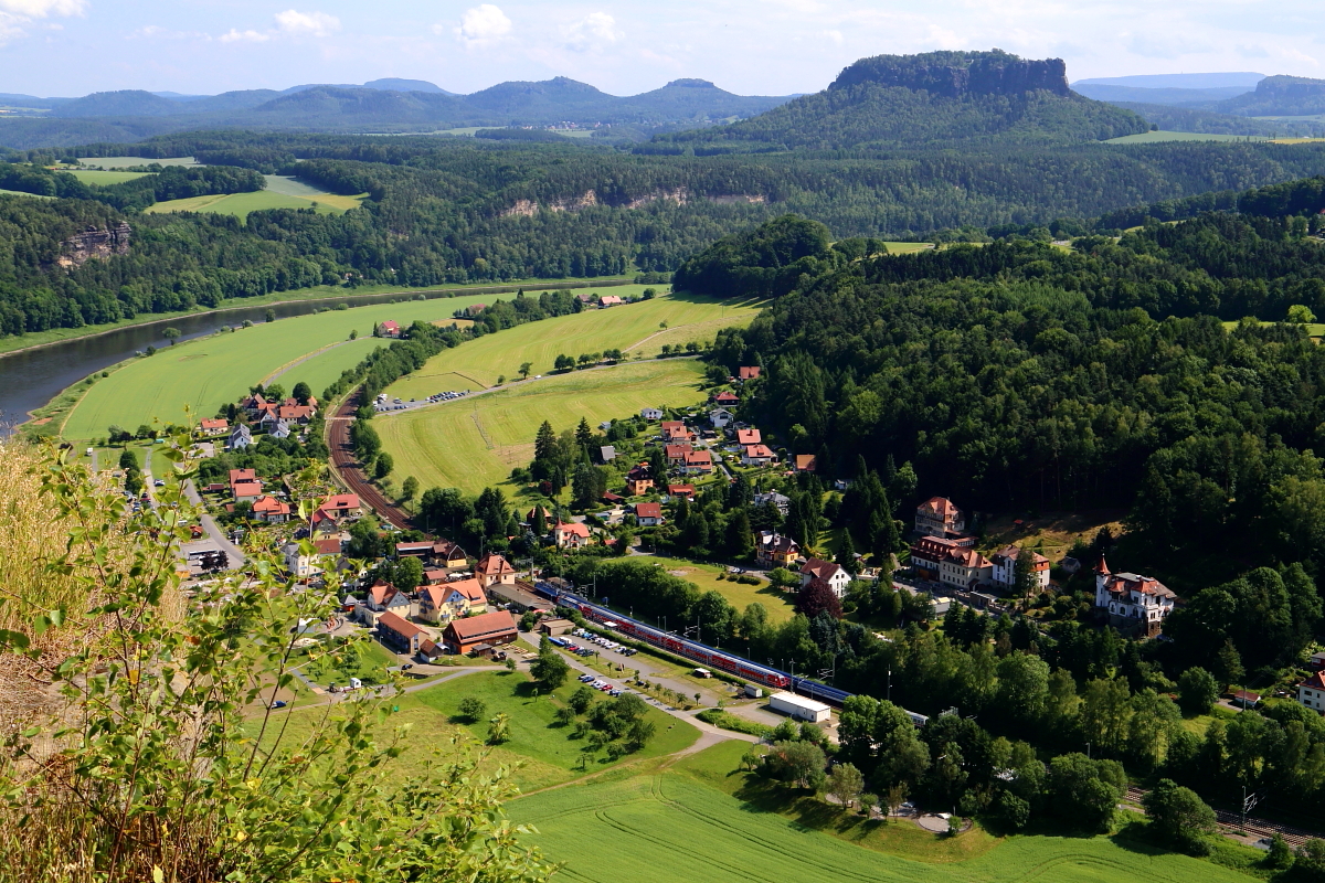Blick am 16.06.2017 vom Bastei-Felsen ins Elbtal. Im Haltepunkt Kurort Rathen begegnen sich gerade ein S-Bahnzug in Richtung Dresden und ein EC in Richtung Tschechien.