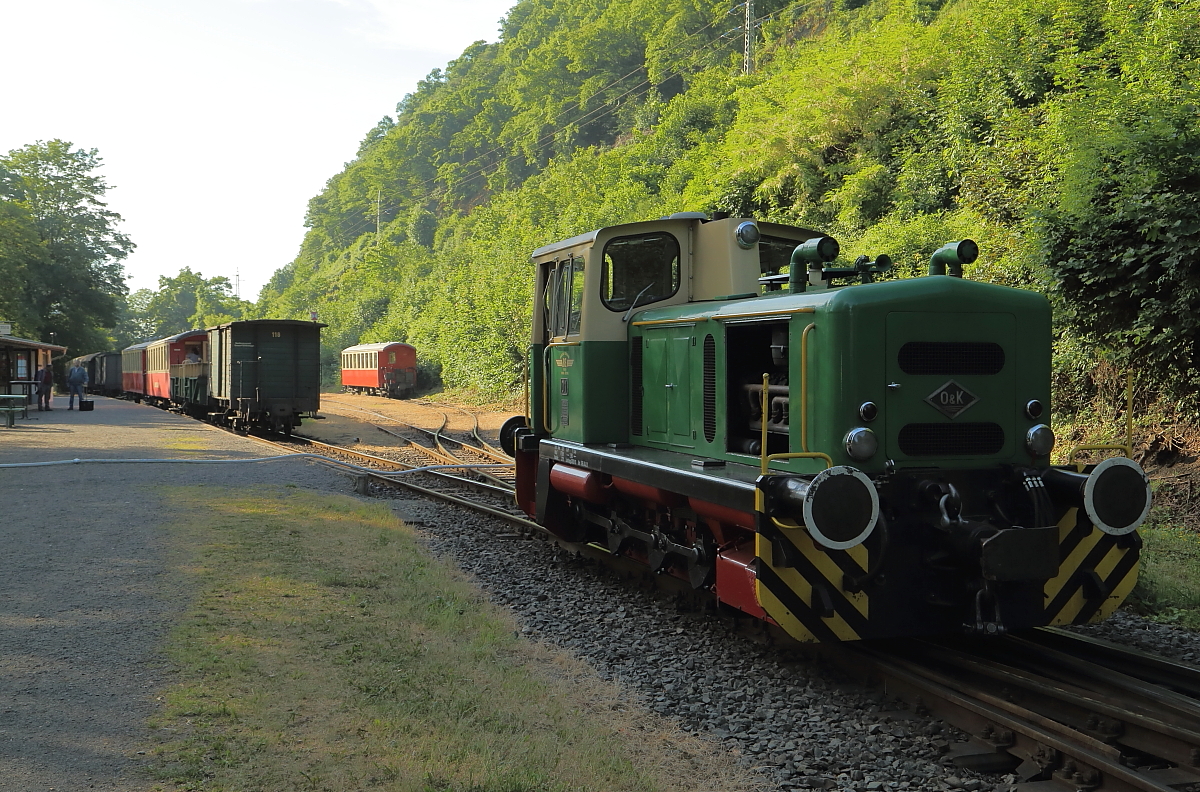 Blick am Morgen des 05.06.2015 in den Bahnhof Brohl-Lützing (BE). Die vorn zu sehende Diesellok D1 wird in Kürze den ersten Planzug des Tages nach Engeln bringen. Noch kann sie jedoch nicht an ihren Zug heranfahren, da das Gleis durch einen C-Schlauch blockiert ist. Dieser füllt gerade einen Hochbehälter, welcher den Wasserkran des Bahnhofes speist, mit dessen Hilfe Mallet-Dampflok 11sm ihre Wasservorräte auffüllen wird. Diese Lok startet dann kurz nach dem Planzug mit einem Sonderzug für Eisenbahnfreunde zu einer Fotosonderfahrt nach Oberzissen.