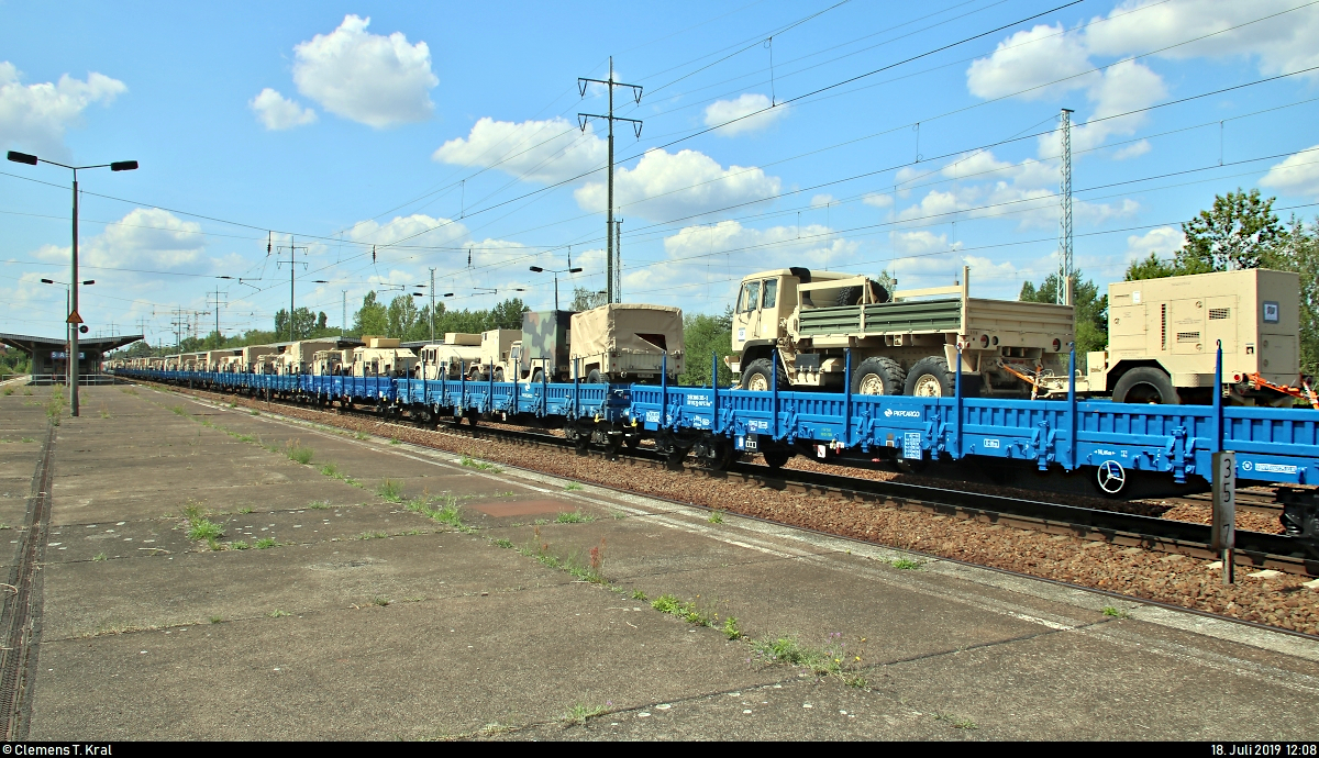 Blick vom anderen Ende auf die 17 polnischen Flachwagen von PKP Cargo S.A., beladen mit verschiedenen Fahrzeugen der United States Army, die in einem Militärzug, kommend vom Grünauer Kreuz, mit Zuglok 145 045-1 DB eingereiht sind und während eines längeren Aufenthalts im Bahnhof Berlin-Schönefeld Flughafen auf dem Berliner Außenring (BAR | 6126) stehen.
[18.7.2019 | 12:08 Uhr]