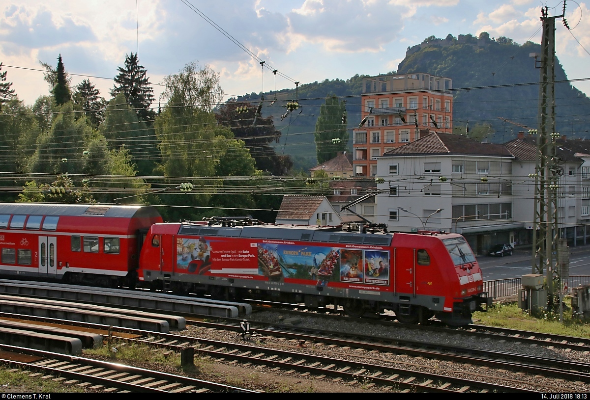 Blick auf 146 229-0, mit Werbung für das Europa-Park-Kombi-Ticket, von DB Regio Baden-Württemberg als RE 4728 von Konstanz nach Karlsruhe Hbf, der den Bahnhof Singen(Hohentwiel) auf Gleis 1 verlässt.
Aufgenommen im Gegenlicht vom Parkhaus in der Julius-Bührer-Straße.
Im Hintergrund ist der 686 m hohe Hohentwiel, der Hausberg Singens, zu erkennen.
[14.7.2018 | 18:13 Uhr]