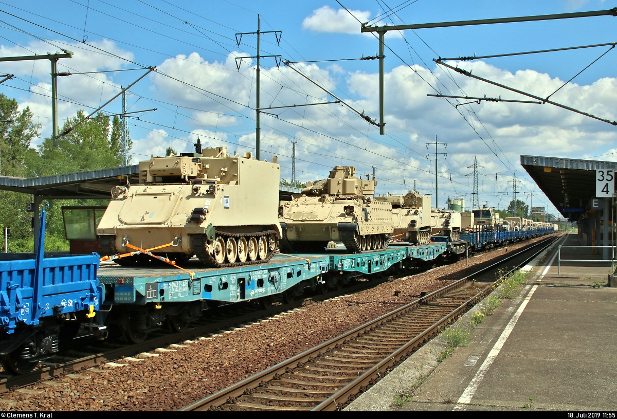 Blick auf die 17 polnischen Flachwagen von PKP Cargo S.A., beladen mit verschiedenen Fahrzeugen der United States Army, die in einem Militärzug, kommend vom Grünauer Kreuz, mit Zuglok 145 045-1 DB eingereiht sind und während eines längeren Aufenthalts im Bahnhof Berlin-Schönefeld Flughafen auf dem Berliner Außenring (BAR | 6126) stehen.
[18.7.2019 | 11:55 Uhr]
