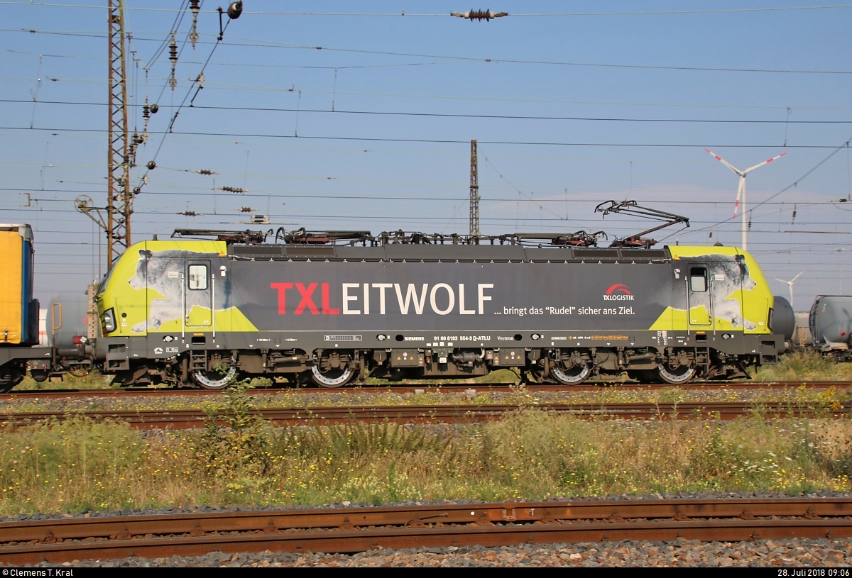 Blick auf 193 554-3 (Siemens Vectron)  TXLEITWOLF  der Alpha Trains Luxembourg S.à r.l., vermietet an die TX Logistik AG, mit Sattelaufliegern auf Flachwagen (KLV-Zug), die den Bahnhof Großkorbetha in nördlicher Richtung durchfährt.
[28.7.2018 | 9:06 Uhr]