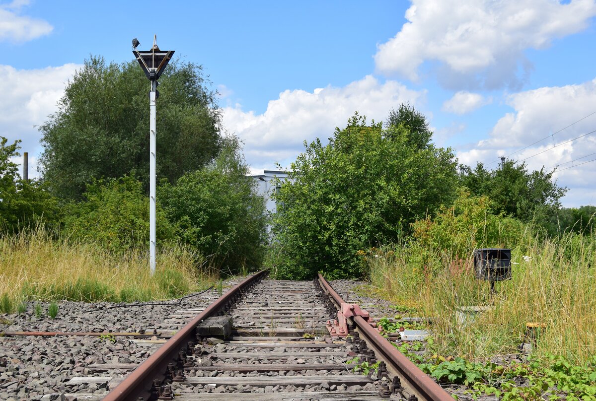Blick auf das Anschlussgleis der ehemaligen Bahnmeisterei in Güterglück. Die Ausfahrt ist mit einer Gleissperre und einem Wärterzeichen ausgestattet. Das Bild wurde von der stillgelegten und nicht mehr angebundenen Verbindungskurve nach Barby gemacht.

Güterglück 22.07.2020