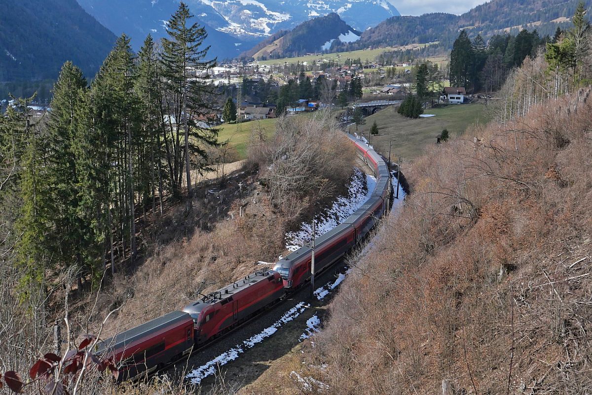 Blick auf die Arlbergbahn Westrampe mit der schiebenden Lok der ersten Railjet-Garnitur und dem Steuerwagen der zweiten Railjet-Garnitur des RJX 165 von Zürich nach Budapest am 19.02.2023 bei Braz