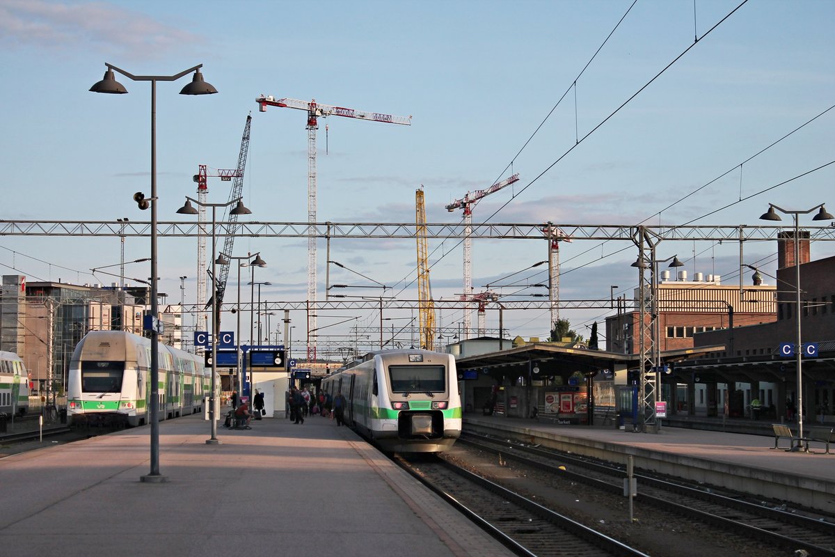 Blick auf den Bahnhof von Tampere am Abend des 10.07.2019, als links der IC 934 (Tampere - Turku) mit der Sr2 3237 und rechts der Sm3 7613 (7 000 013-3) als S 148 (Tampere - Helsinki) standen und auf ihre Ausfahrten warteten.
