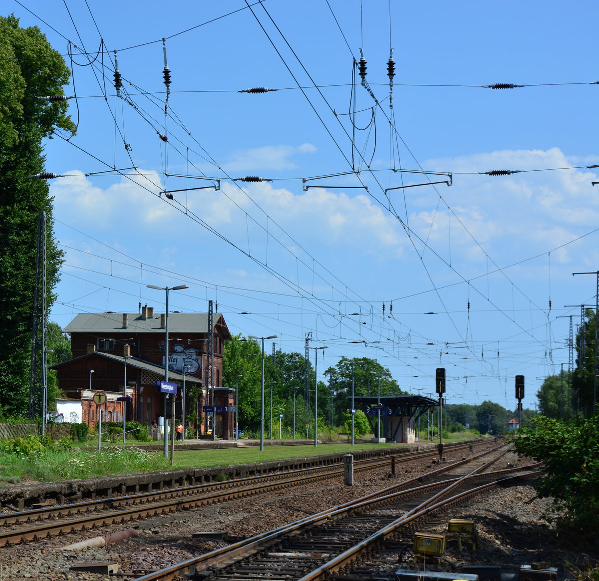 Blick auf den Bahnhof Wiesenburg. Hier in der Region ist die meiste Eisenbahn Infrastruktur noch weites gehend unberührt seit dem Bauerfall. Wiesenburg ist eine sehr letzten Bahnhöfe an Hauptstrecken wo die Fahrgäste noch über die Gleise zum Inselbahnsteig gehen, daher wird hier vor und nach jeden Zug der Bahnsteig wieder abgesperrt. Früher als die Kanonenbahn nach Güterglück noch in Betrieb war fuhr hier sogar der Fernverkehr entlang. 

Wiesenburg 01.08.2017