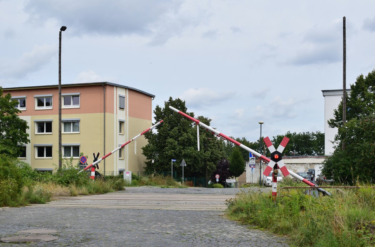 Blick auf dem BÜ Oststraße in Naumburg Ost während des Schließvorgangs. Der Bahnübergang besitzt mechanische Halbschranken mit einer WSSB Lichtzeichenanlage. 

Naumburg 11.08.2021