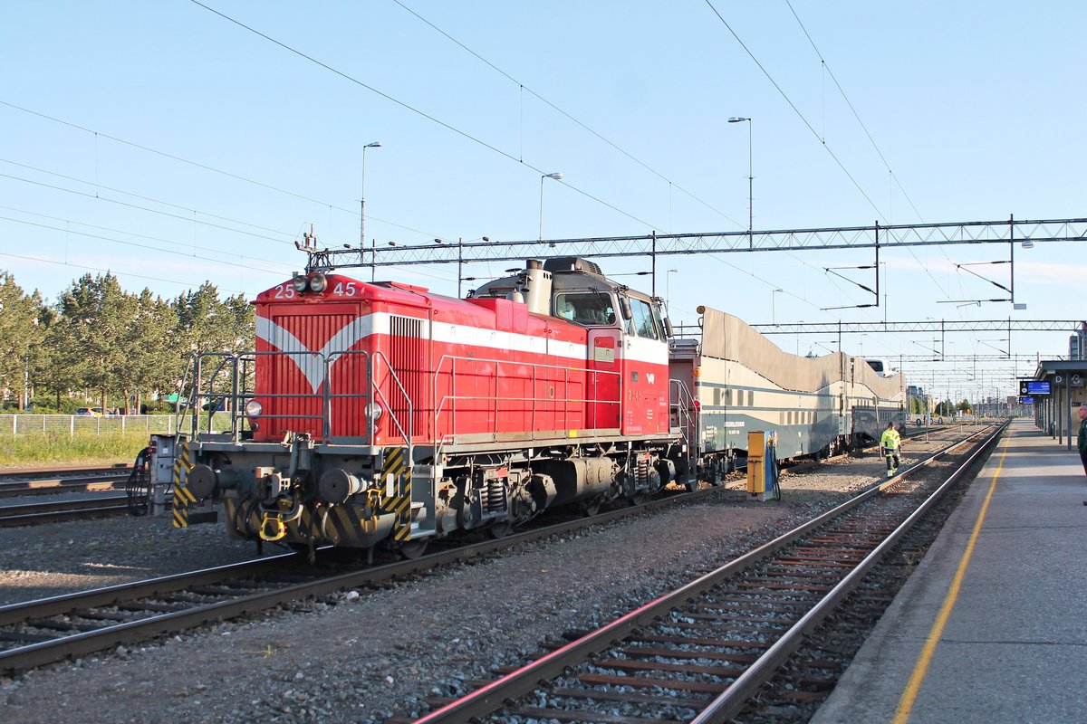 Blick auf die Dv12 2545, welche am Abend des 08.07.2019 mit den zwei Autotransportwagen VR 31023-5 und VR 31034-2 (Bauart Gfot) neben den Bahnsteigen im Bahnhof von Oulu stand und sie gleich Richtung Norden raus ziehen wird, um sie dann später an den Nacht-IC 266 (Rovaniemi - Helsinki) zu rangieren.