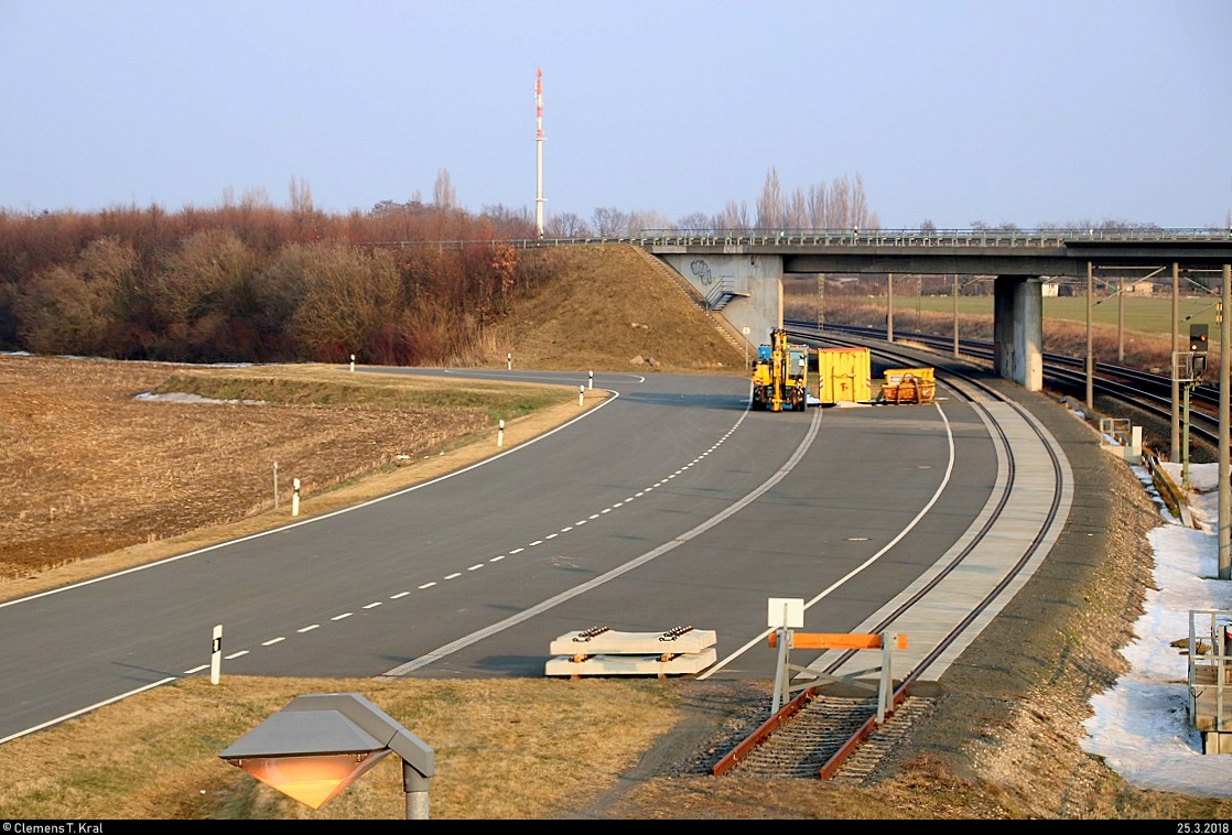 Blick auf ein drittes Gleis als Stumpfgleis, kommend von der Anschlussstelle (Anst) Edisonstraße in Schkeuditz (ehem. zum Flughafengelände), neben dem Hp Schkeuditz West auf der Bahnstrecke Magdeburg–Leipzig (KBS 340). Zu sehen sind ebenfalls Baucontainer, ein Zweiwegebagger und zwei Betonteile für Schienen. [25.3.2018 | 18:13 Uhr]