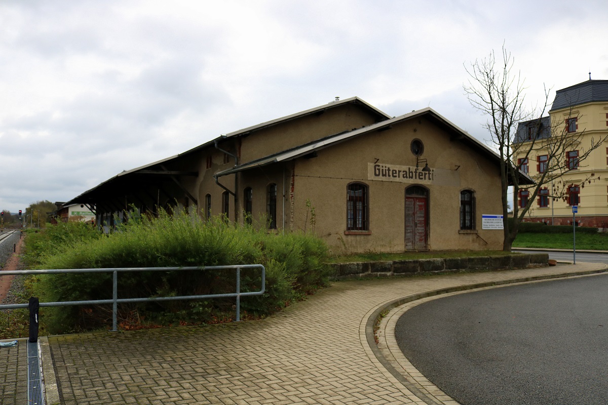 Blick auf ein ehemaliges Gebäude für die Güterabfertigung im Bahnhof Geithain hinter den Bahnsteigen. Die Aufschrift ist noch großenteils zu erkennen. [31.10.2017 | 11:10 Uhr]