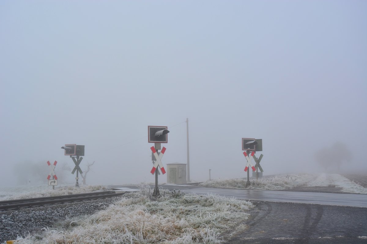 Blick auf einem Bahnübergang mit Blinkanlage bei frostig nebeligen Wetter in Girod im Westerwald.

Girod 03.12.2016