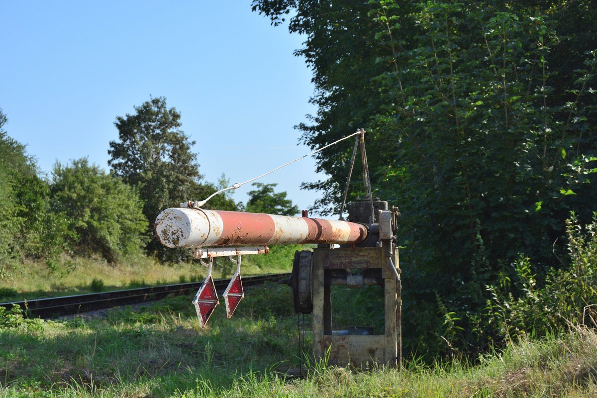 Blick auf einen alten Schrankenbaum am Bahnübergang Edgerslebener Straße in Bottmersdorf. Neben der Besonderheit das dies ein mechanischer Bahnübeergang mit Halbschranken ist, ist diese Schranke noch mit kleinen Reflektoren ausgestattet.  Mit der Streckenertüchtigung auf 120km/h und dem Umbau des Bahnhofs Blumenberg auf ESTW wird dieser Bahnübergang auch durch eine moderne Anlage ersetzt. 

Bottmersleben 25.07.2019 
