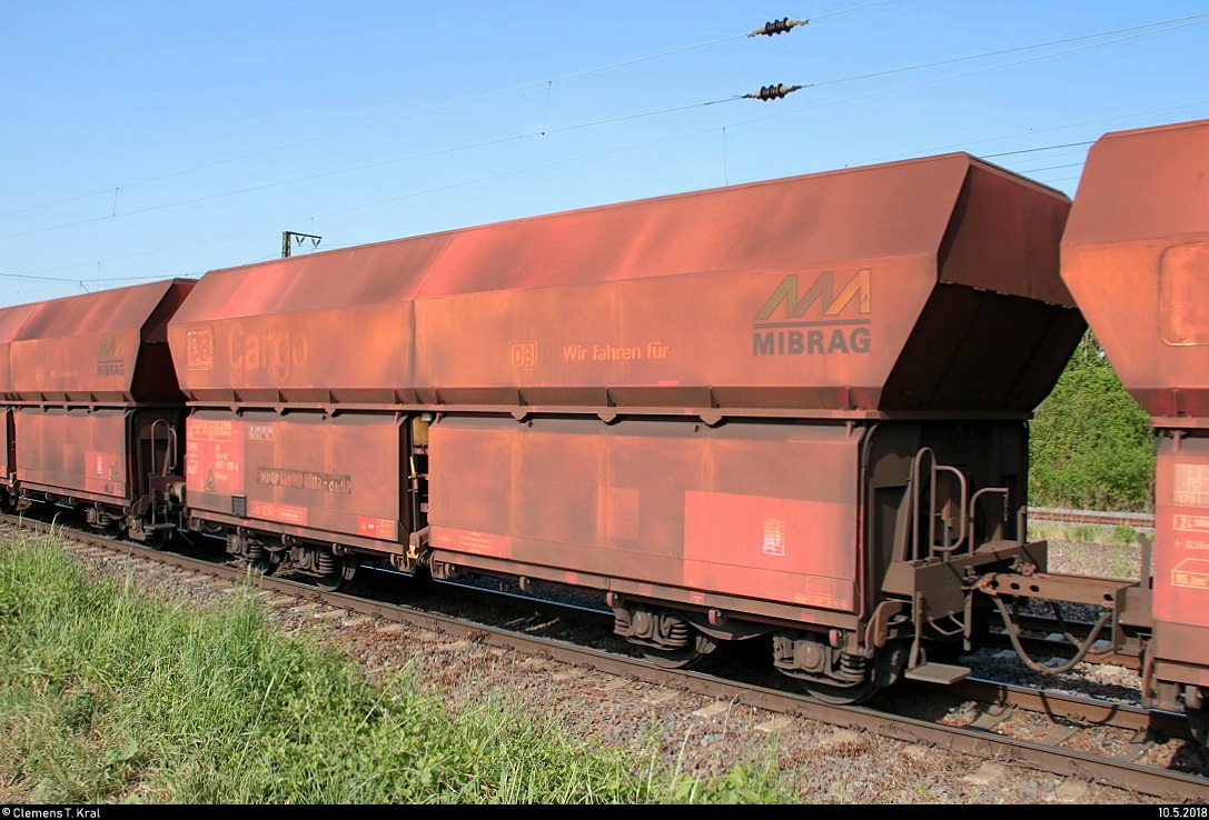 Blick auf einen offenen Drehgestell-Schüttgutwagen mit schlagartiger Schwerkraftentladung der Gattung  Falnqqs 130  (82 80 6647 103-2 D-DB) der DB, im Auftrag der Mitteldeutschen Braunkohlengesellschaft mbH (MIBRAG), der in einem Kohlezug vom Kraftwerk Schkopau nach Wählitz zum Braunkohlerevier Profen mit 275 218 (MaK G 1206 | Lok 218) der Mitteldeutschen Eisenbahn GmbH (MEG) eingereiht ist und in Großkorbetha auf der Bahnstrecke Großkorbetha–Deuben (6812) fährt.
[10.5.2018 | 9:16 Uhr]