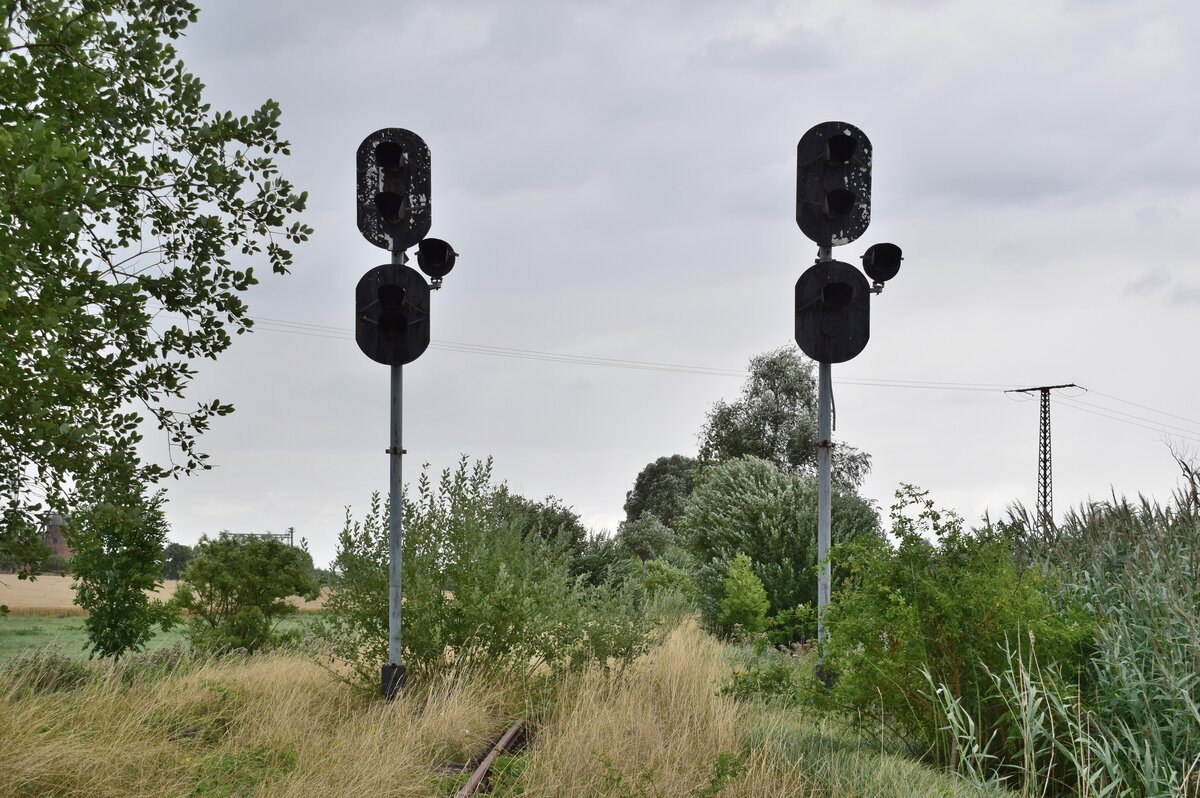 Blick auf die EZMG Ausfahrsignale in Richtung Salzwedel. Das Stellwerk ist leergeräumt sodass hier die EZMG Signale wohl nie mehr leuchten werden.
Die Strecke wurde 2004 durch die DB stillgelegt und zum 1. Januar 2007 von der DRE zur Streckensicherung gepachtet. Da auf dem Abschnitt Klötze - Oebisfelde von den Kommunen kein Interesse am Schienenverkehr vorlag wurde die Strecke 2008 durch die DRE abgebaut. Auf dem Abschnitt Salzwedel - Klötze befuhren 2014 und 2015 Sonderfahrten. Seither ist die Strecke ohne Verkehr und wächst stetig zu. 

Siedenlangenbeck 31.07.2021
