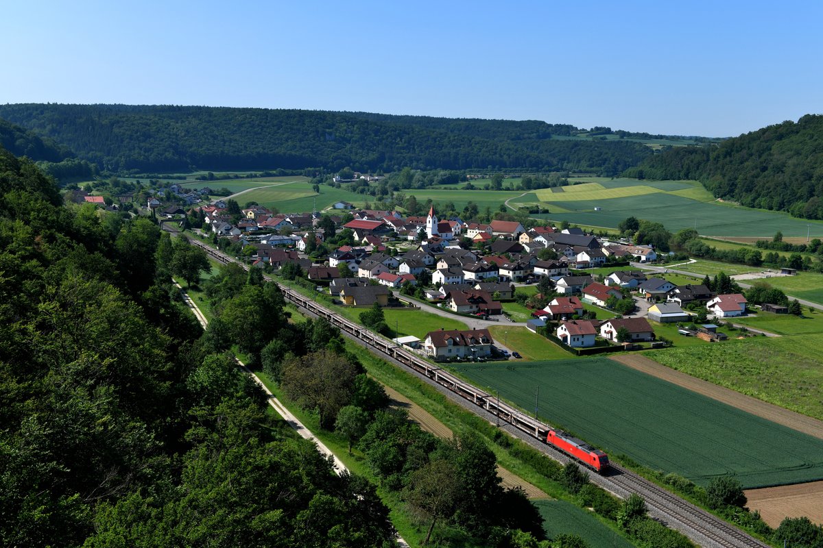 Blick auf den Ort Breitenfurt im Altmühltal. Die Ruhe wurde nur kurz unterbrochen, als 185 212 mit einem leeren Autotransportzug in Richtung Ingolstadt durch die malerische Landschaft rauschte (05. Juni 2019).