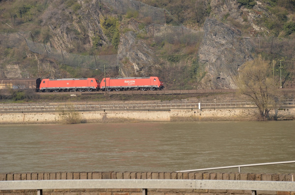 Blick auf die rechte Rheinseite.....185 305 und 185 304 fahren südwärts mit einem Schiebewandwagen bei Kestert am Montag den 6.4.2015