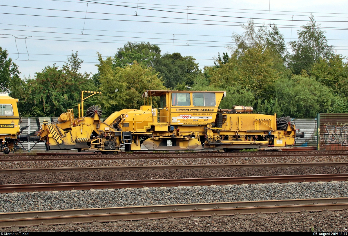 Blick auf Schotterplanier- und Profilierungsmaschine Deutsche Plasser SSP 110 SW (99 80 9425 008-6 D-HFW) der Wiebe Holding GmbH & Co. KG, die zusammen mit Gleisstopfmaschine Plasser & Theurer 08-275 Unimat 3S  K 4S  Bremen  (99 80 9124 006-4 D-HFW) desselben Unternehmens den Bahnhof Hamburg-Harburg auf Gleis 10 Richtung Hamburg-Wilhelmsburg durchfährt.
Aufgenommen von Bahnsteig 5/6.
[5.8.2019 | 16:47 Uhr]