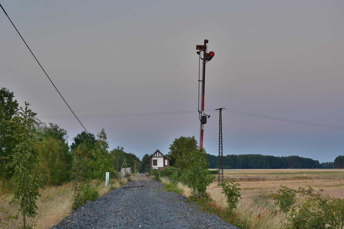 Blick auf die seit 2004 stillgelegte Blockstelle Flötz. Einem Blocksignal wurde bereits der Flügel entwendet. Der umgekippte Mast links wurde bis 2020 wieder aufgestellt. Es wird bereits überlegt diesen Streckenteil zwischen Barby und Güterglück zu reaktivieren.

Gödnitz 26.07.2018