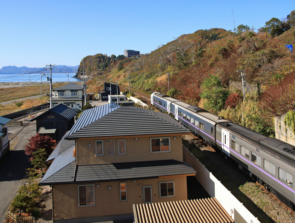 Blick auf die Strecke: Ein Triebzug der Serie 261-1000 unterwegs von Sapporo nach Hakodate fährt in Tôya gerade unter der Strassenbrücke hindurch. Die vordersten Wagen sind ein neueres Endwagenpaar, dann folgt ein schon etwas älterer Triebwagen ohne Führerstand. 26.Oktober 2022  