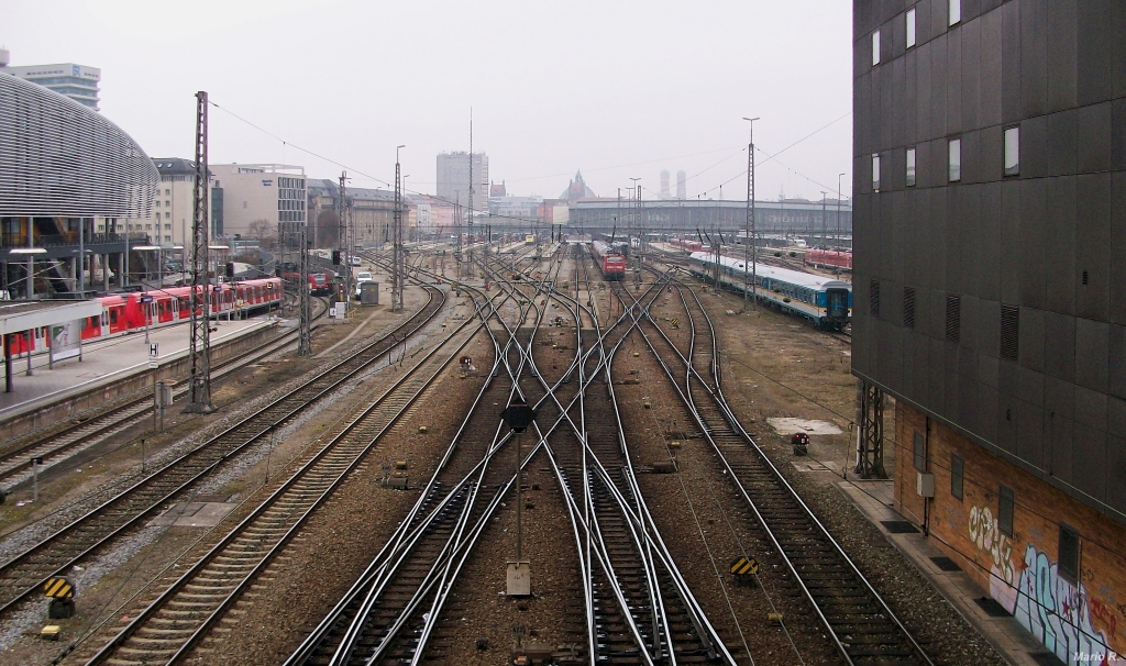 Blick auf das Vorfeld des Münchner Hauptbahnhofs eines trüben April-Tages 2013. Zu sehen gibt es an dieser Stelle nicht nur rechts das große Münchner Stellwerk, sondern links auch den ZOB und die Haltestelle  Hackerbrücke . Der Fotograf stand hier am 5.4.13 auf selbiger.