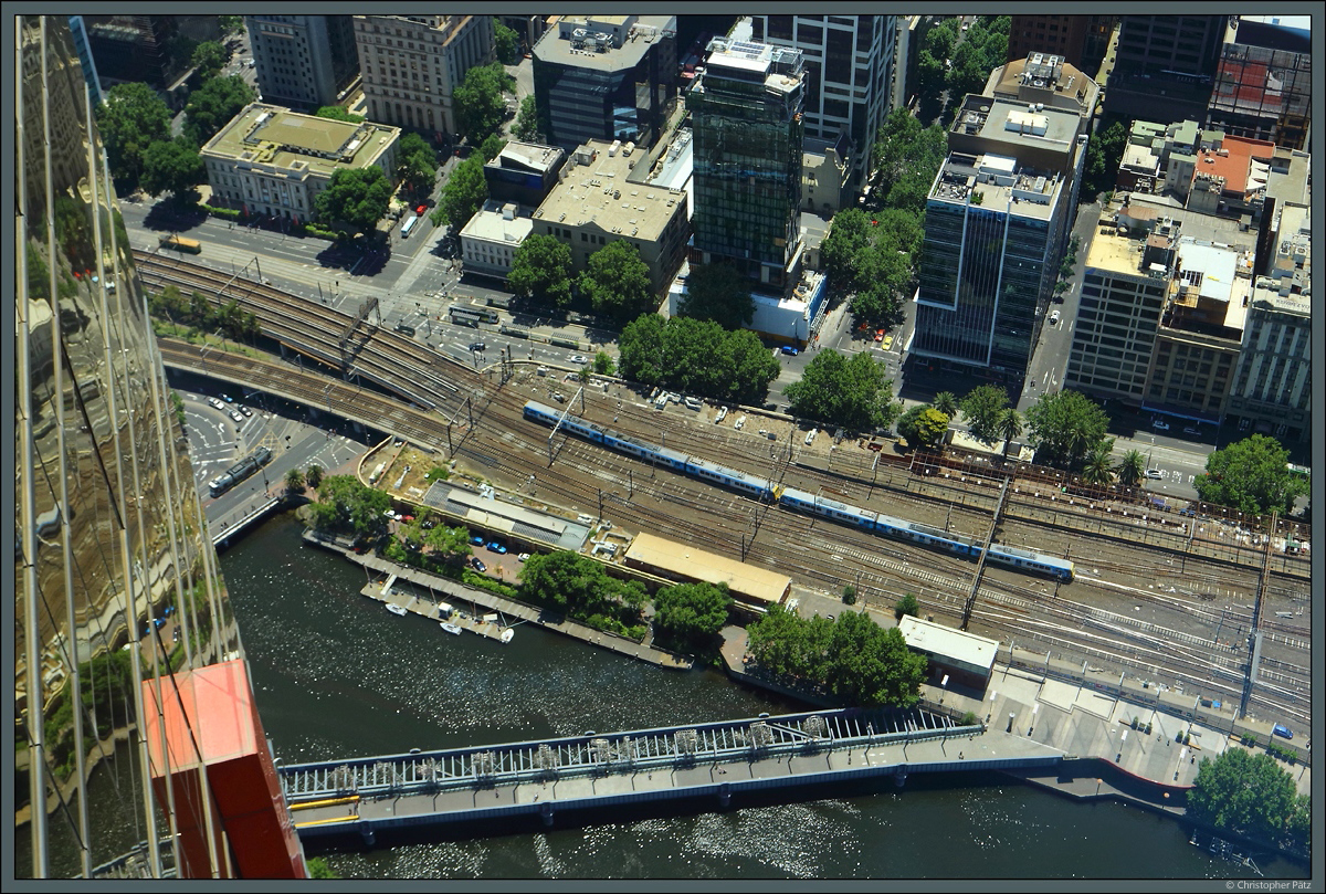 Blick aus dem 297 m hohen Eureka-Tower auf das Gleisvorfeld des Bahnhof Flinders Street: Ein X'Trapolis 100-Pärchen der Metro Trains Melbourne erreicht am 30.12.2019 den Bahnhof im Zentrum von Melbourne. 