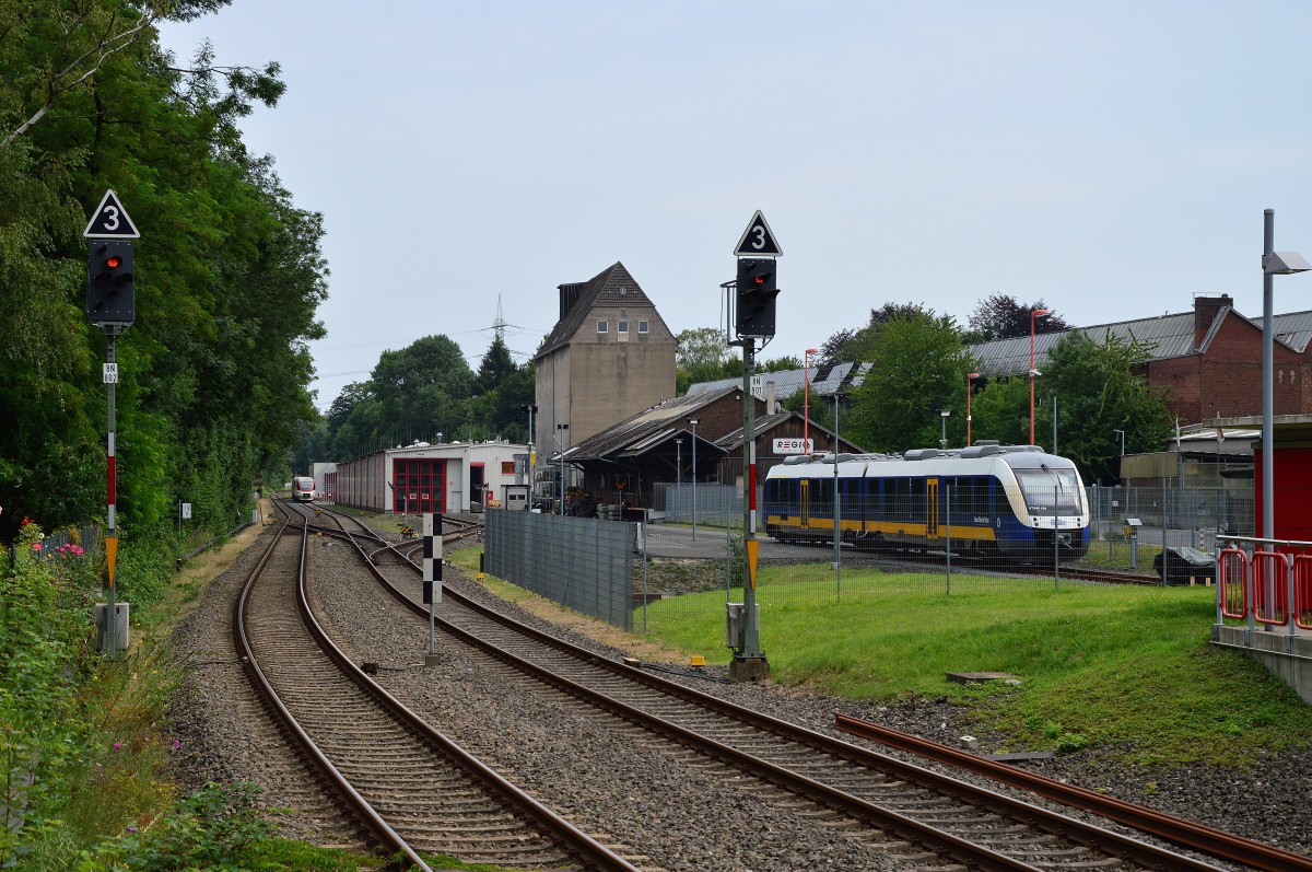 Blick aus dem Bahnhof Mettmann Stadtwald in Richtung Hahnenfurth, rechts auf dem Betriebsgelände steht ein NWB Triebwagen und am Ende des Geländes auf dem Gleis Richtung Dornap stehen zwei 643 der Regiobahn. 9.8.2015