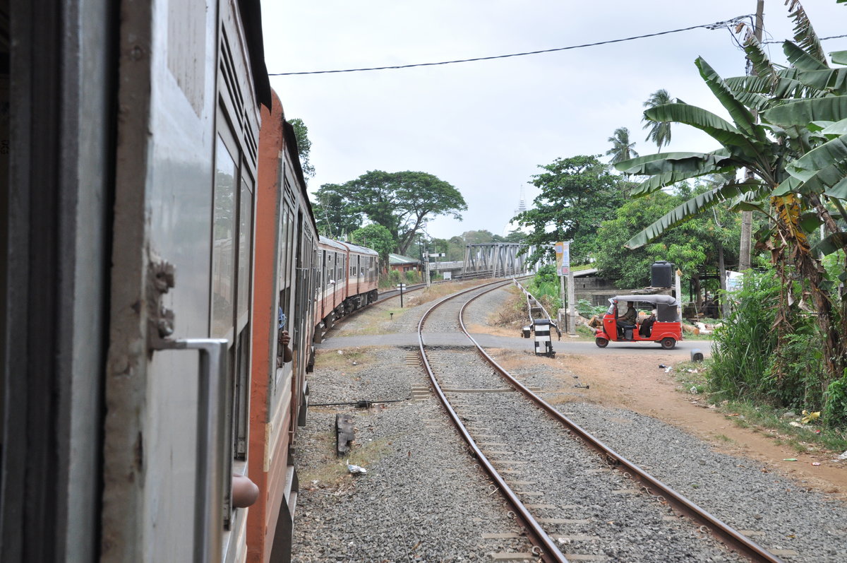 Blick aus dem Triebwagen S8 auf der Fahrt von Aluthgama nach Colombo. Die fehlenden Türen der Züge sind für Europäer besonders interessant.  ;-) Das Foto entstand kurz vor der Überfahrt über den Kalu bei Kalutara im August 2010.