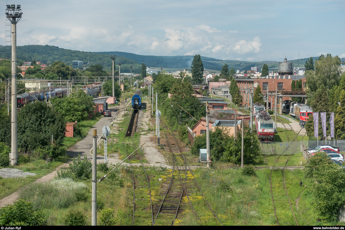 Blick von der Brücke der Strada Locomotivei über das Abstellfeld und ins Remarul-Werk in Cluj-Napoca am 10. Juli 2018. Im Remarul-Werk werden diverse Loks und Triebwagen modernisiert oder neu gebaut.