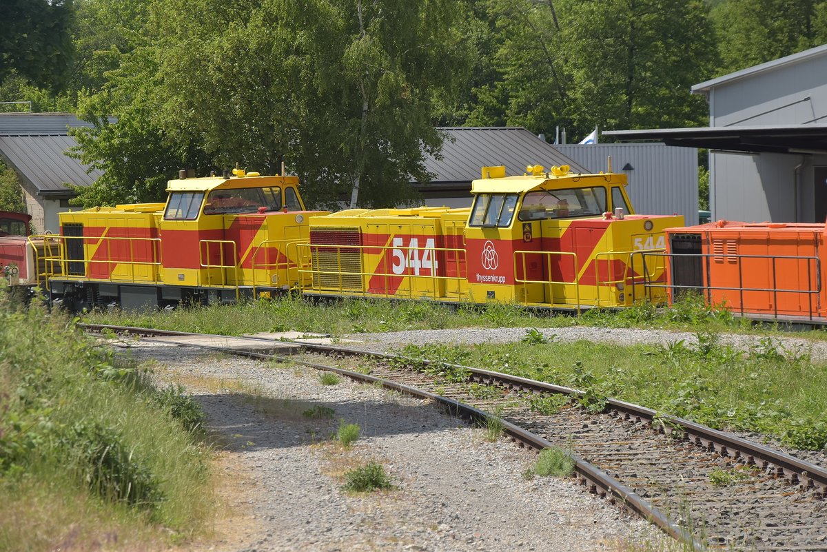 Blick durch ein Zaunelement am Einfahrtstor ins Werksgelände von Gmeinder in Mosbach.
Im tieferliegenden Werksgelände stehen zwei unbekannte Dieselloks die wohl für die Thyssen/Krupp Werke in Duisburg bestimmt sind, auf der hinteren mehr verdeckten Maschine ist die Betriebsnr. 544 zu erkennen. Mosbach den 29.5.2020