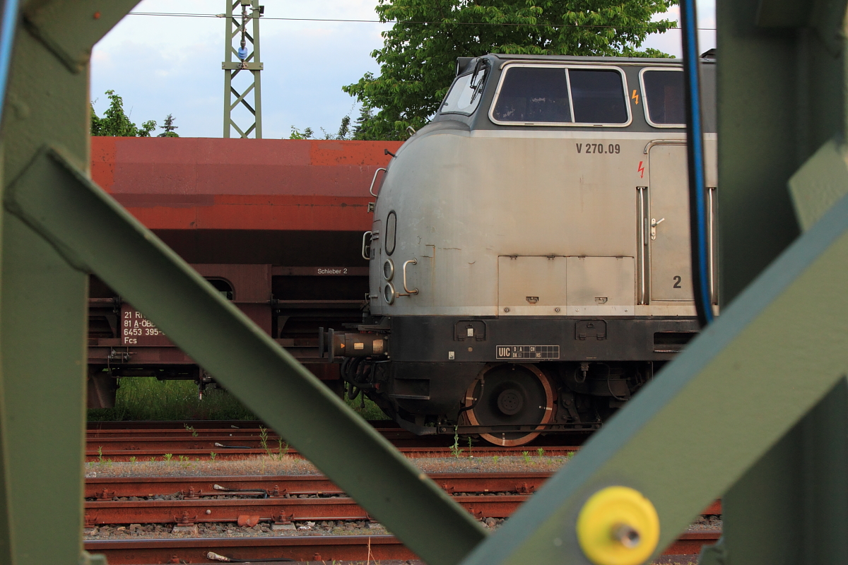 Blick durch einen Mast auf den Führerstand 2 der 221 121-7 SGL V270.09 in Hochstadt/ Marktzeuln am 09.06.2016. (Bild wurde vom Bahnsteig gemacht)