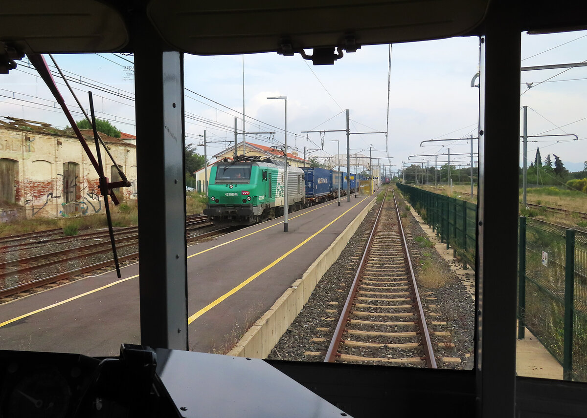Blick durch den Führerstand des Train Rouge auf den durchfahrenden Güterzug Richtung Norden im Bahnhof Rivesaltes. Rivesaltes, 25.5.2023
