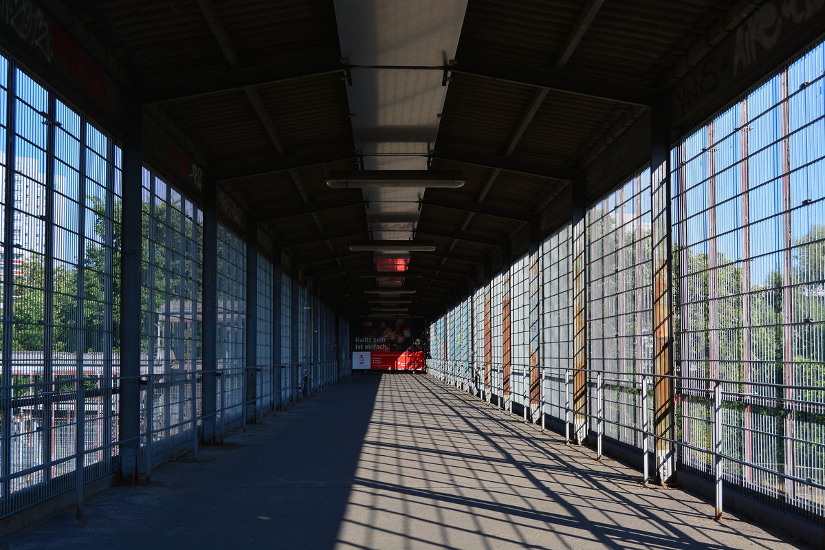 Blick durch die Überführung zur Märkischen Allee und zum S-Bahnsteig Berlin Marzahn. Ehemals deckte Drahtglas die Überführung ab. Dieses wurde jedoch so oft zerstört das heute nur noch Zäune die Außenseite sichern und das Glas komplett entfernt wurde.

Berlin Marzahn 23.07.2018