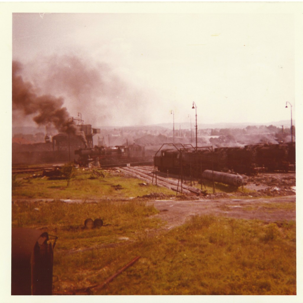 Blick ins BW Crailsheim am 16.08.1970. Es raucht noch kräftig aber bald ist es mit dieser Pracht auch vorbei.Auf der Drehscheibe befindet sich gerade eine Baureihe 50 mit Kabinentender. Das Foto stammt von meinem Vater Franz Bauch.