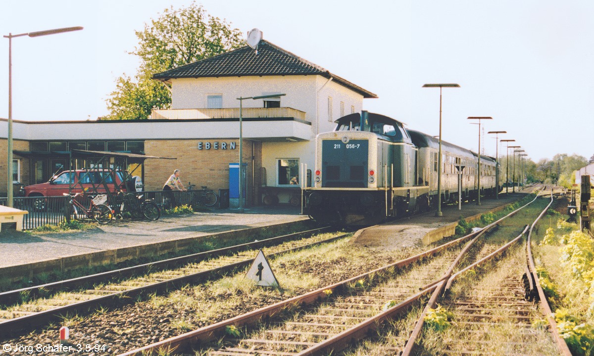 Blick nach Norden auf 211 056, die am 3.5.94 an der Spitze eines „Sandwichzuges“ im Bahnhof Ebern auf die Rückfahrt nach Bamberg wartete. Heute ist alles auf dem Bild Geschichte, da die Gleise und alle Gebäude abgebrochen wurden.