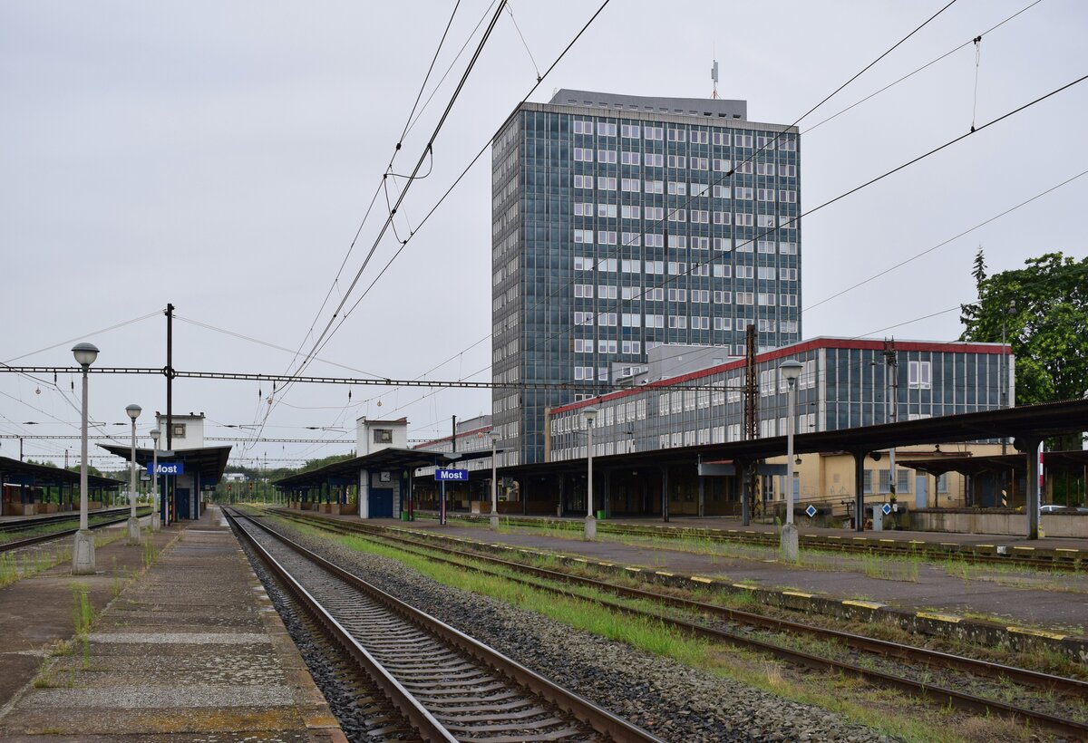 Blick über die Bahnsteige sowie das Empfangsgebäude in Most. Besonders fällt hierbei das hohe Empfangsgebäude auf. WÄhrend unten die Wartehalle mit Ticketschalter, Bahnhofskneipe und Imbiss ist sind in den oberen Etagen vermutlich Büroräume.

Most 29.07.2023