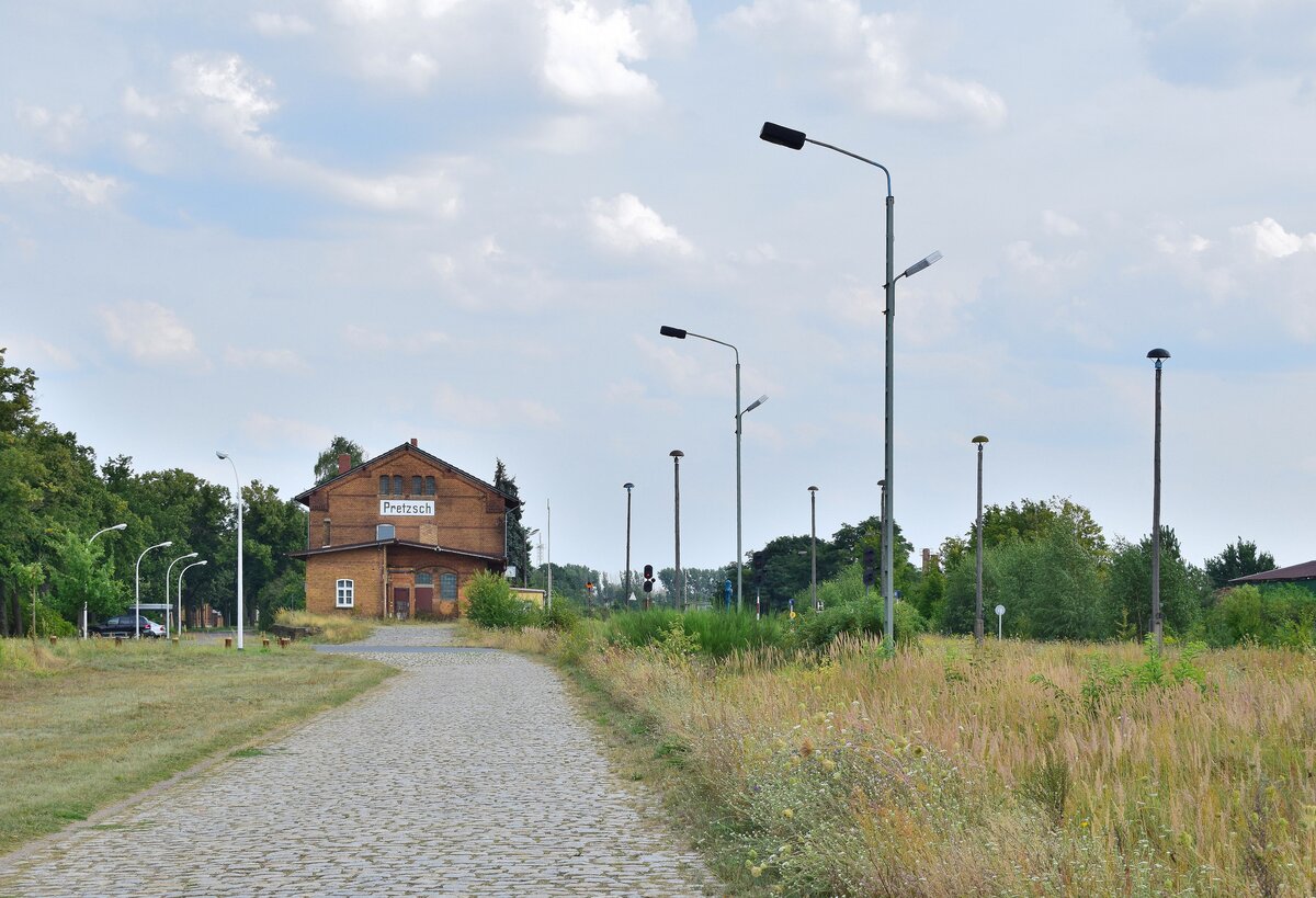 Blick über die geplfasterte Strecke zum Bahnhof und das verwilderte Gleisfeld in Pretzsch. 1998 wurden die durchgehenden Züge nach Eilenburg eingestellt und der letzte Ast von Wittenberg nach Bad Schmiedeberg Ende 2014 eingestellt. Zuletzt gab es hier 2017 Sonderzüge. Ende 2019 wurde die Strecke wegen Oberbaumängeln betrieblich gesperrt. Seitdem verwildern einige Teile der Strecke zusehens.

Pretzsch 13.08.2021