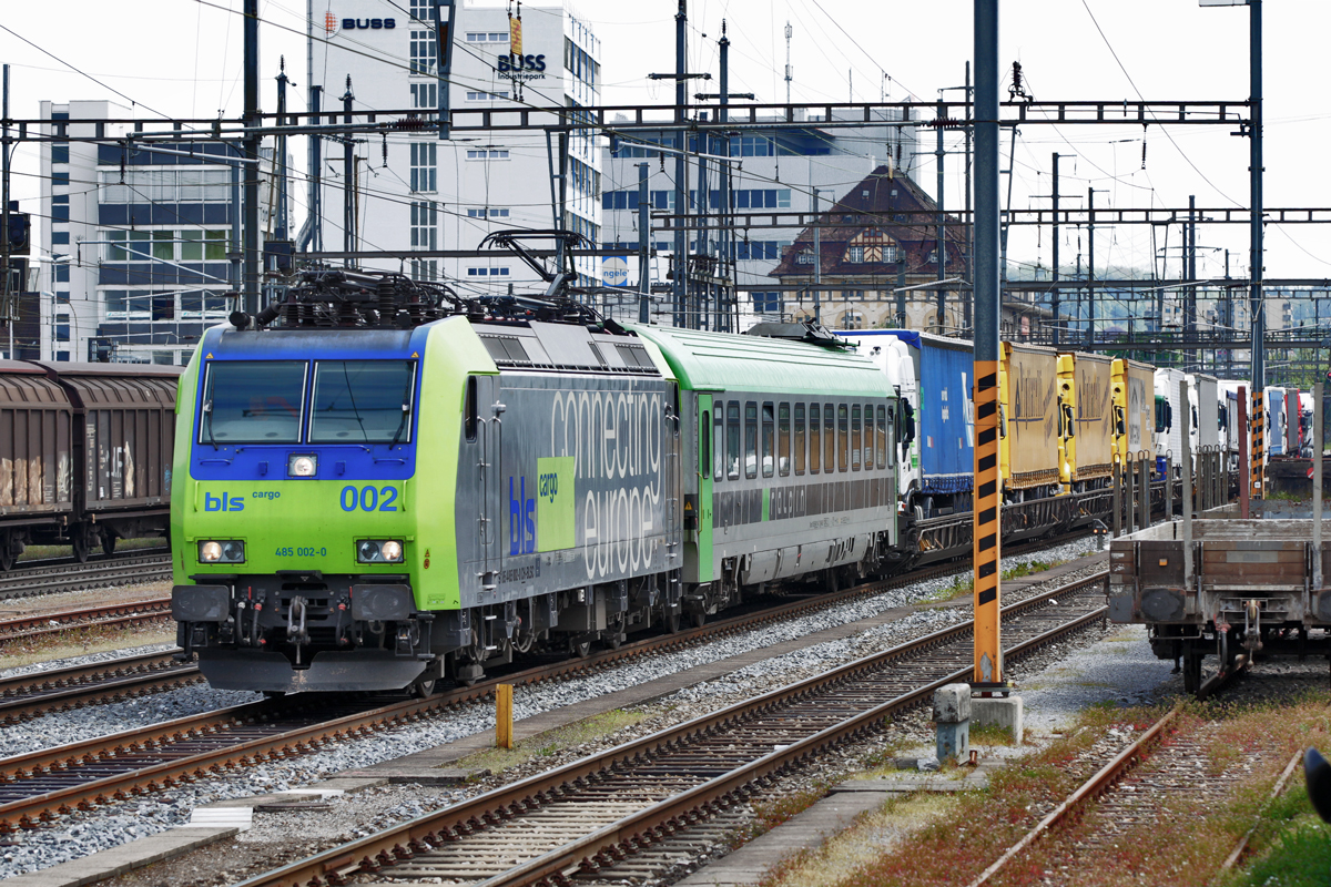 Bls 485 002-2 fährt in Pratteln mit einer RoLa vorüber.Bild vom 9.5.2015