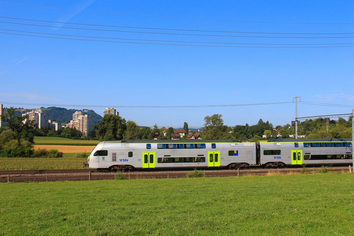 BLS Doppelstocktriebzug RABe 515  Mutz : Auch die früher eher beschauliche Stadt Bern wächst brutal in die Landschaft hinaus. Hinter dem Endwagen von RABe 515 018 ist noch der Gebäudekomplex des Schlosses Wittigkofen zu sehen, wo es noch richtig spukte; doch das Land, das zum Schloss gehörte, ist nun eine Betonwüste. 31.Juli 2017. 