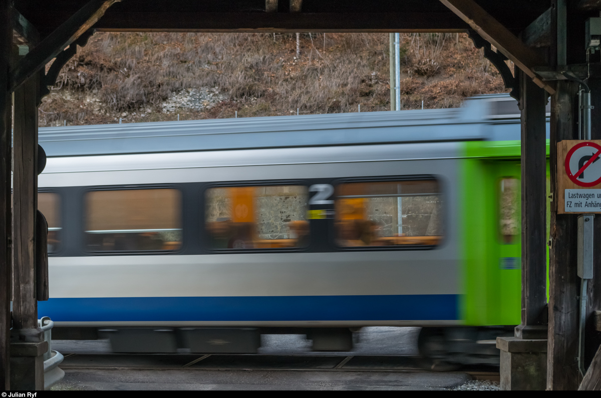 BLS EW III am 12. Dezember 2015 bei Trubschachen.
Die überdachte Holzbrücke schliesst direkt an den unbewachten Bahnübergang an.