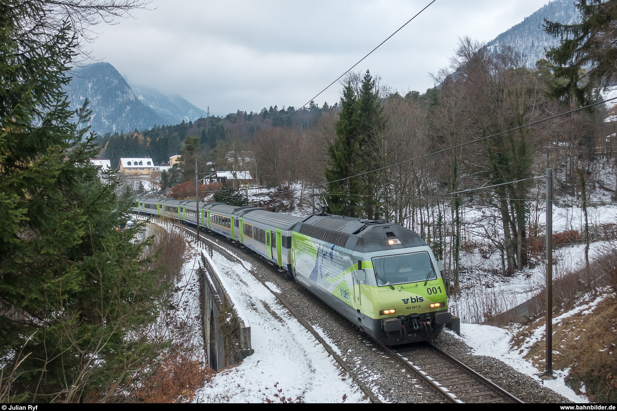 BLS Re 465 001 mit Beklebung zum Jubiläum  10 Jahre Lötschberg Basistunnel  am 2. Dezember 2017 mit einem RE Bern - La Chaux-de-Fonds oberhalb von Chambrelien.