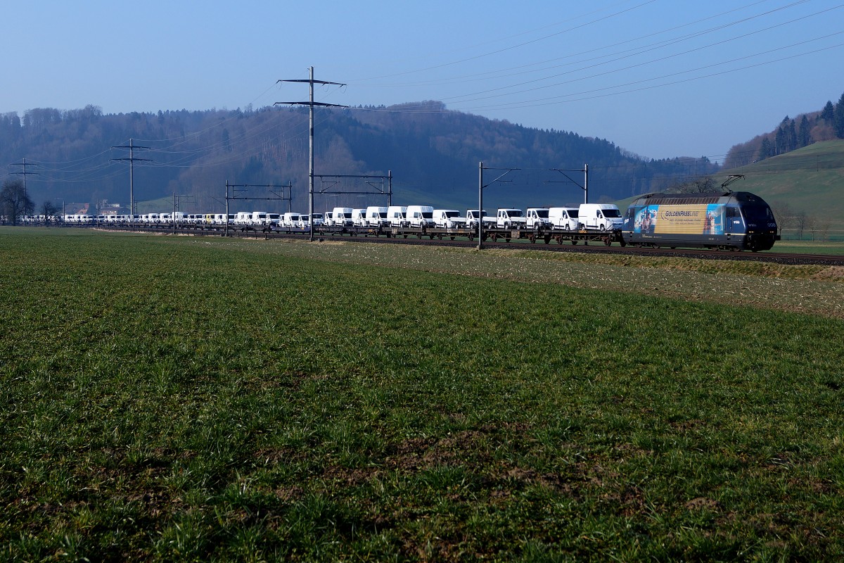 BLS: Sehr langer Autozug mit Re 465 008  GOLDENPASS  bei Bollodingen am 8. März 2014. Tronsportiert werden Nutzfahrzeuge der Marke FIAT. 
Foto: Walter Ruetsch