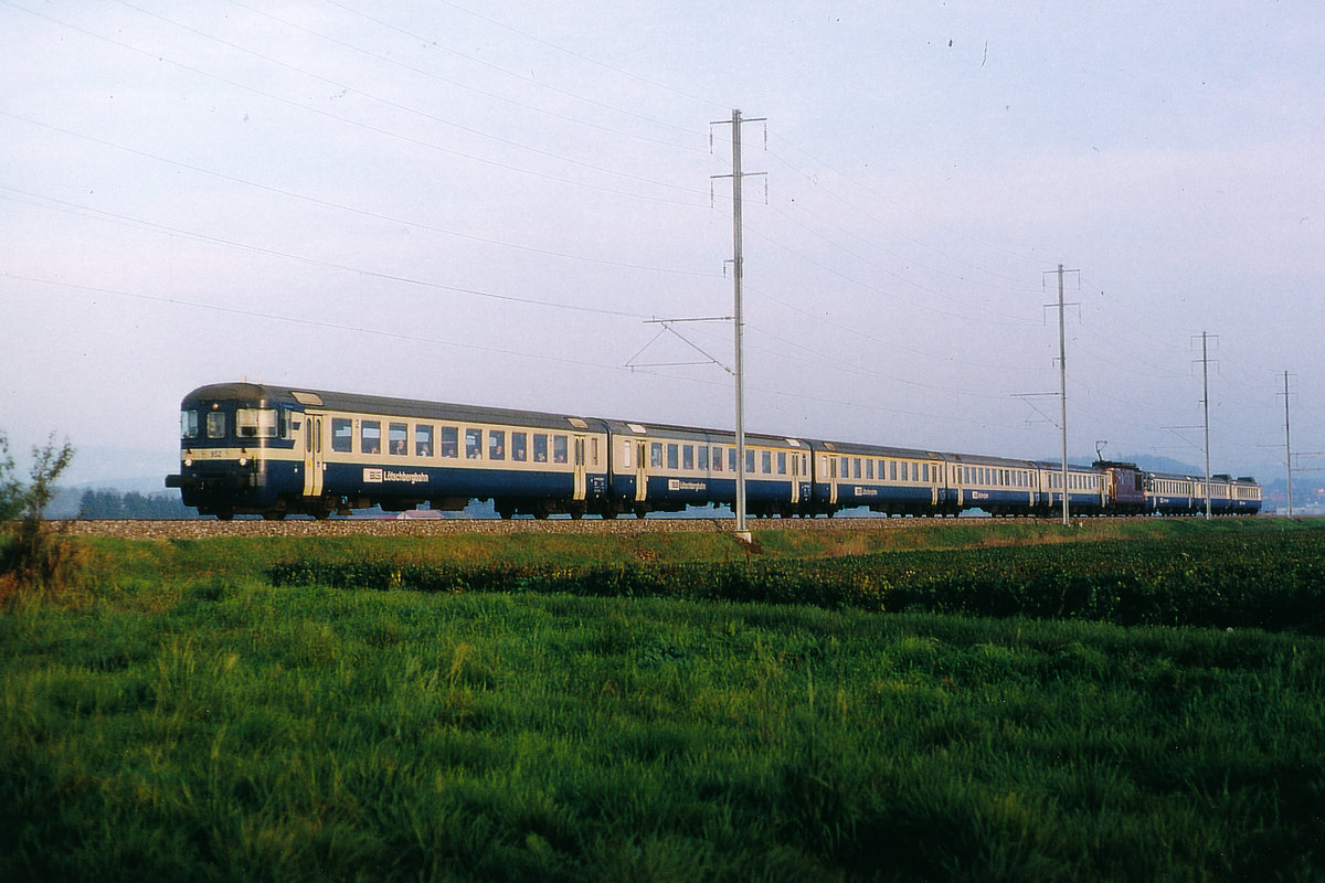 BLS/BN: RE Neuchâtel-Bern bei Müntschemier am 17. Oktober 2001. Jeweils am späteren Nachmittag wurden damals einzelne Re 4/4-Pendelzüge mit bis zu drei Wagen verstärkt.
Foto: Walter Ruetsch  