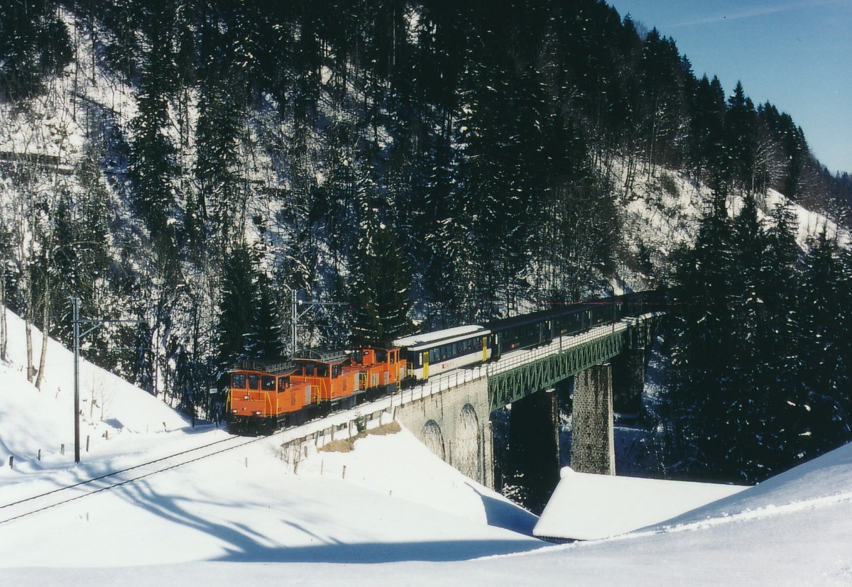 BLS/SEZ: Da am 26. Dezember 1999 durch den Sturm  LOTHAR  der elektrische Betrieb auf der SEZ zum Erliegen kam, wurde kurzfristig auf Dieselbetrieb umgestellt. Die Ersatzfahrzeuge für den Planbetrieb wurden kurzfristig von der BOB (Bayerische Oberlandbahn) zur Verfügung gestellt. Für die Führung des alljährlichen  Sonderzuges zum Jugendskilager kamen gleich drei Dieselloks zu Ehren. Sonderzug mit drei Dieselloks und EW II-Wagen auf dem Bunschenbach-Viadukt bei Weissenburg am 2. Januar 2000.
Foto: Walter Ruetsch   