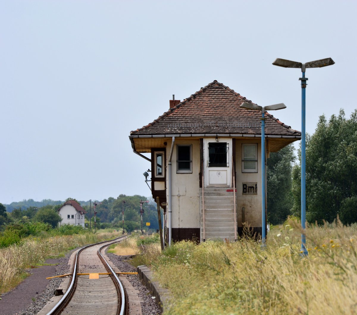 Blumenberg hat seine besten Zeiten schon lange hinter sich. Bis in die 90er Jahre war Bluemberg ein wichtiger Knotenpunkt. Hier trafen sich einmal 4 Strecken. Blumenberg-Wanzleben-Eilsleben, Blumenberg-Schönebeck, sowie Blumenberg-Egeln-Staßfurt wurden zwischen 1999 und 2002 alle samt stillgelegt und so bleibt heute nur noch die Strecke Magdeburg-Halle. Von den ehemals 3 Bahnsteigen und 6 Bahnsteiggleisen ist heute nur noch ein Bahnsteig in Betrieb. Gehalten wird hier nur noch bei Bedarf. Ende des Jahres zum Fahrplanwechsel wird der Halt in Blumenberg aufgegeben. 2020 soll auch die mechanische Signal und Sicherungstechnik durch ein ESTW ersetzt werden und die Strecke auf 120km/h durchgängig ausgebaut werden. Somit dürfte es nach dem Umbau mit dem Bahnhof Blumenberg entgültig zu Ende gehen. Blick auf das Stellwerk Bmf.

Blumenberg 21.07.2018