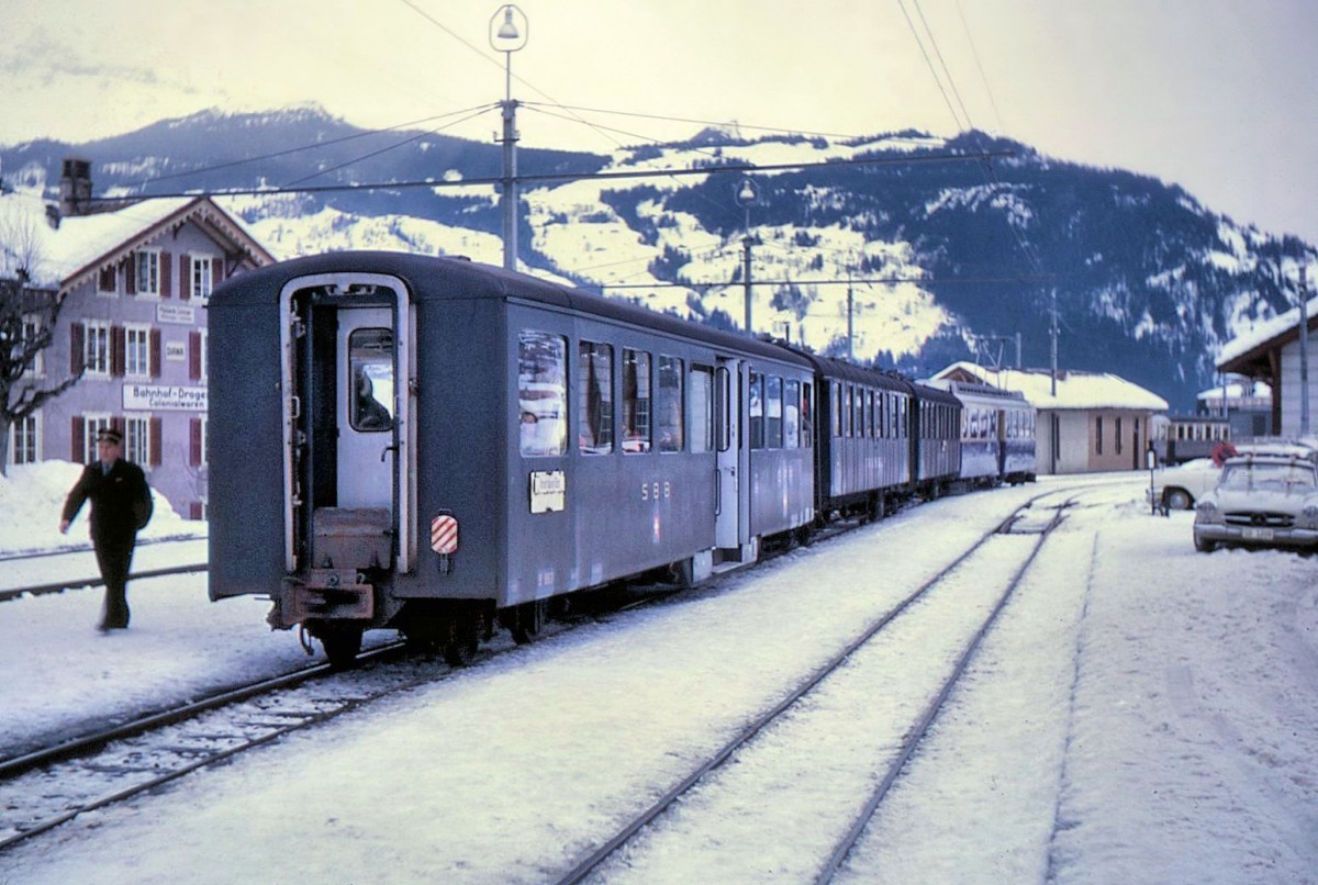 BOB-Entlastungszug mit drei Wagen der SBB-Brünigbahn, BOB-Triebwagen 305, dahinter die beiden alten Wagen B 817 und AB 451, zuhinterst der Leichtmetallwagen B 863. Grindelwald, 2.Januar 1966. 