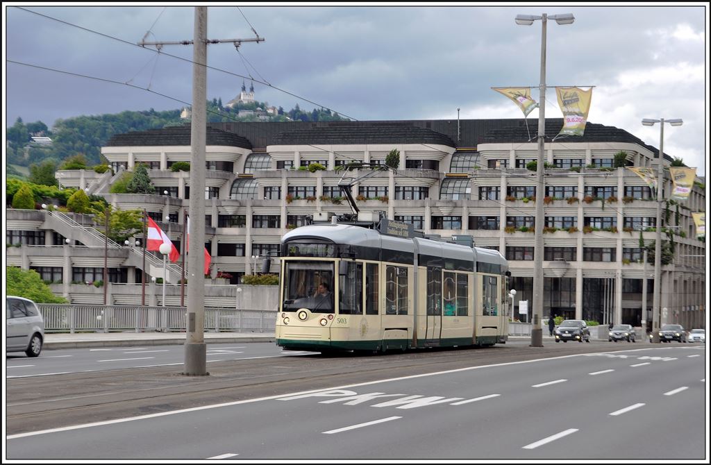 Bombardier Mountainrunner 503 der Pöstlingbergbahn auf der Nibelungenbrücke über die Donau in Linz. Im Hintergrund ist nich das Ziel der Bergbahn zu sehen. (30.05.2014)