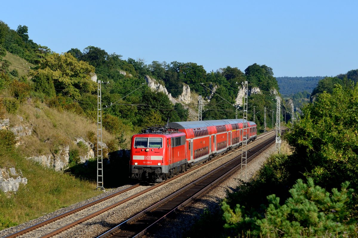 Braves Arbeitstier ist die Baureihe 111 und zwischen München und Treuchtlingen aktuell noch unermüdlich im Einsatz. Am 26. August 2016 passierte 111 219 mit ihrem RE 57314 bei Hagenacker die für diese Gegend charakteristischen Felsformationen.
