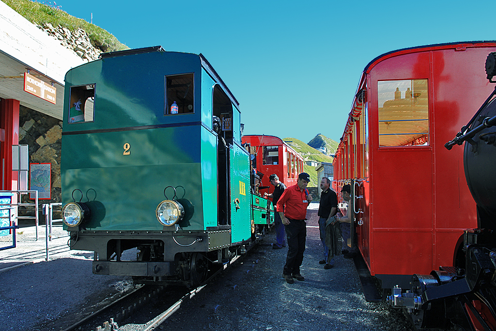 BRB: Erlebnis mit dem Salon Rouge. Unser Zug mit Lok2 von 1891 sowie Wagen B27 von 1936 und M3 von 1937 hat Rothorn Kulm erreicht. Wir gesellen uns zum Dampfzug mit Lok6 sowie Wagen B16 und B26 von 1933. Es bleiben nur noch wenige Minuten zum Plaudern mit dem freundlichen Personal, dann geht's wieder talwärts nach Brienz. Aufnahme vom 09. Sept. 2016, 12:43